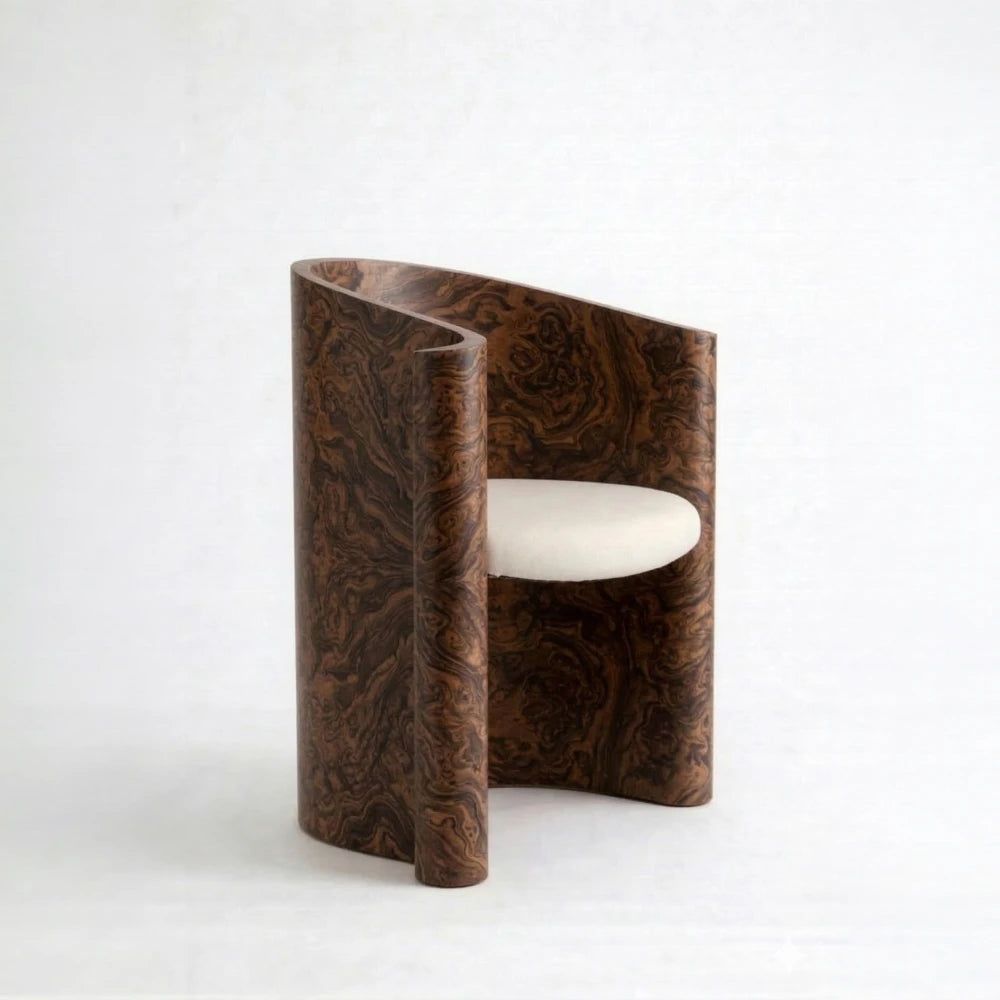 Volute Chair by Garnier Pingree in California Burl, with dark swirling wood grain, curved sides and a cream upholstered seat.